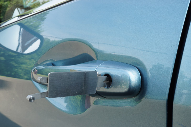 image of a car door lock being picked with professional tools